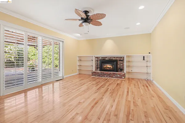 a view of empty room with fireplace and wooden floor