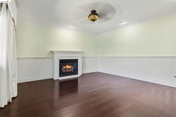 an empty room with wooden floor and a fireplace