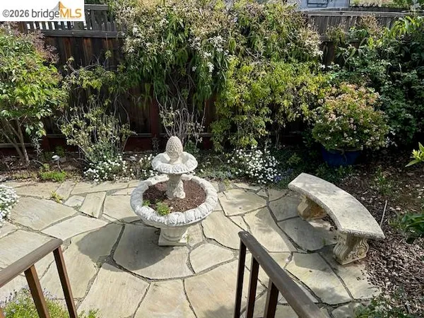a patio with a table and chairs and potted plants
