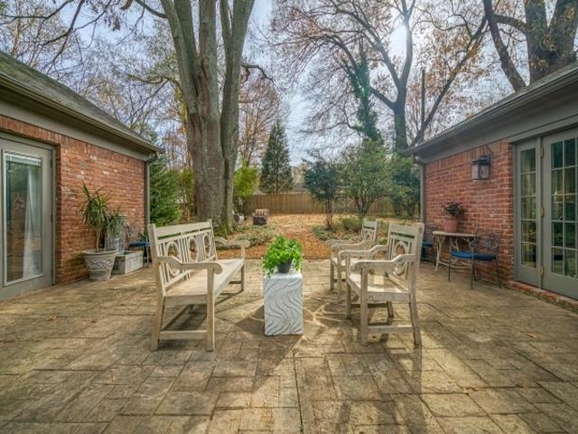 4309 Sequoia Road Memphis, TN 38117 - Photo 24 of 25 a view of a patio with table and chairs and couches with wooden fence and large trees
