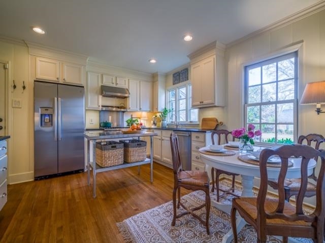 4309 Sequoia Road Memphis, TN 38117 - Photo 6 of 25 a kitchen with granite countertop a refrigerator a stove a dining table and chairs