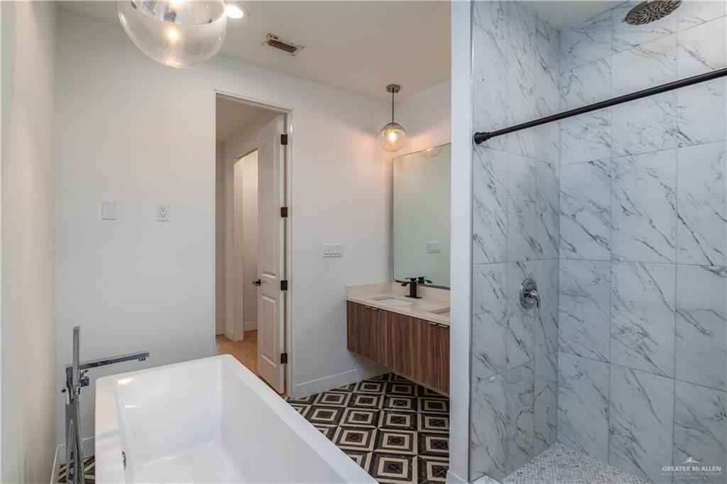 915 Santa Lucia Street Mission, TX 78572 - Photo 14 of 23 Bathroom with double vanity, a marble finish shower, and a freestanding bath
