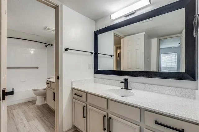a bathroom with a sink a toilet and a large mirror