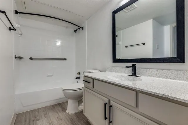 a bathroom with a granite countertop sink a toilet and a mirror