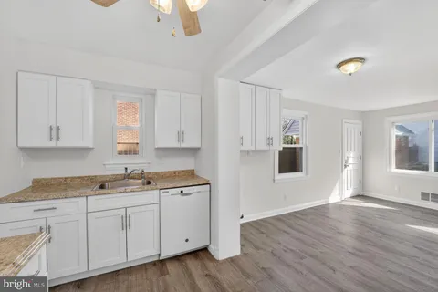 a kitchen with a sink cabinets and wooden floor