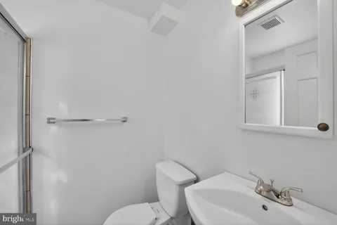 a bathroom with a sink mirror and toilet