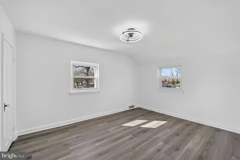 an empty room with wooden floor and window