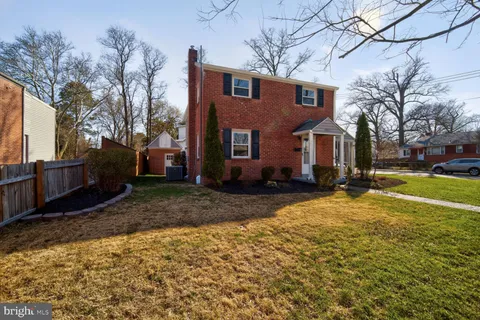 a brick house with a yard covered in snow