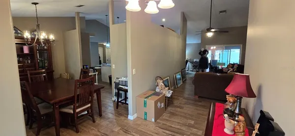 a living room with furniture a chandelier and a flat screen tv