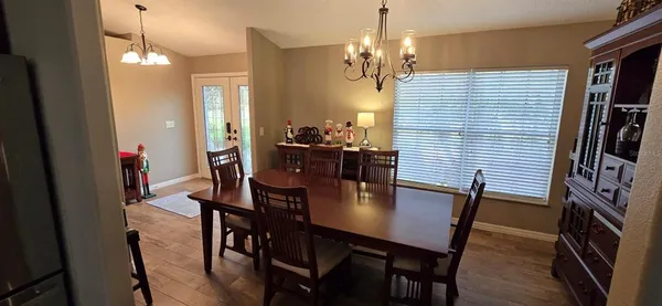 a living room with furniture a dining table and a chandelier