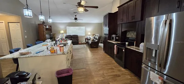 a view of kitchen with sink refrigerator dining table and chairs