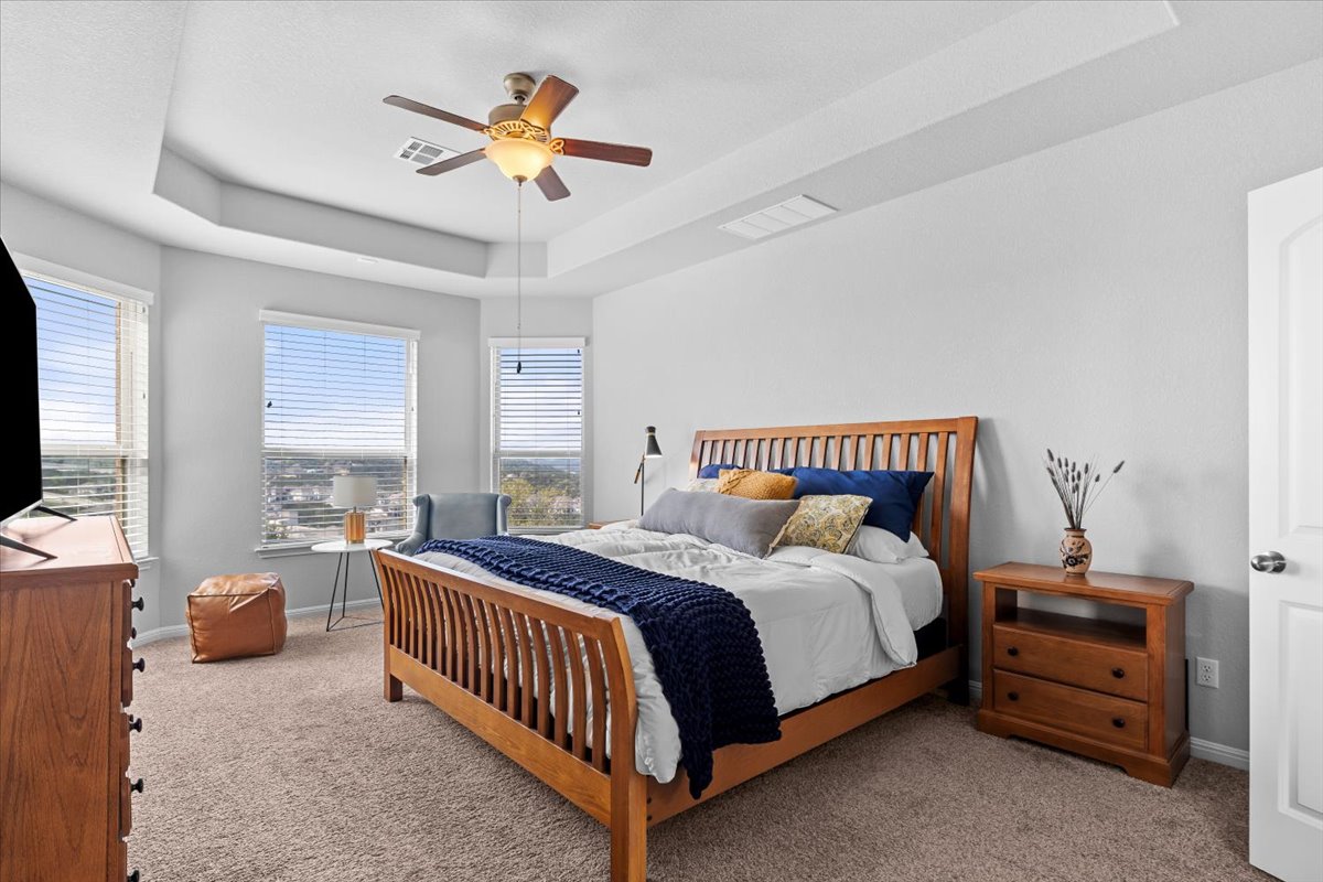 2733 Painted Sky Bend Leander, TX 78641 - Photo 19 of 35 a bedroom with a bed and a chandelier