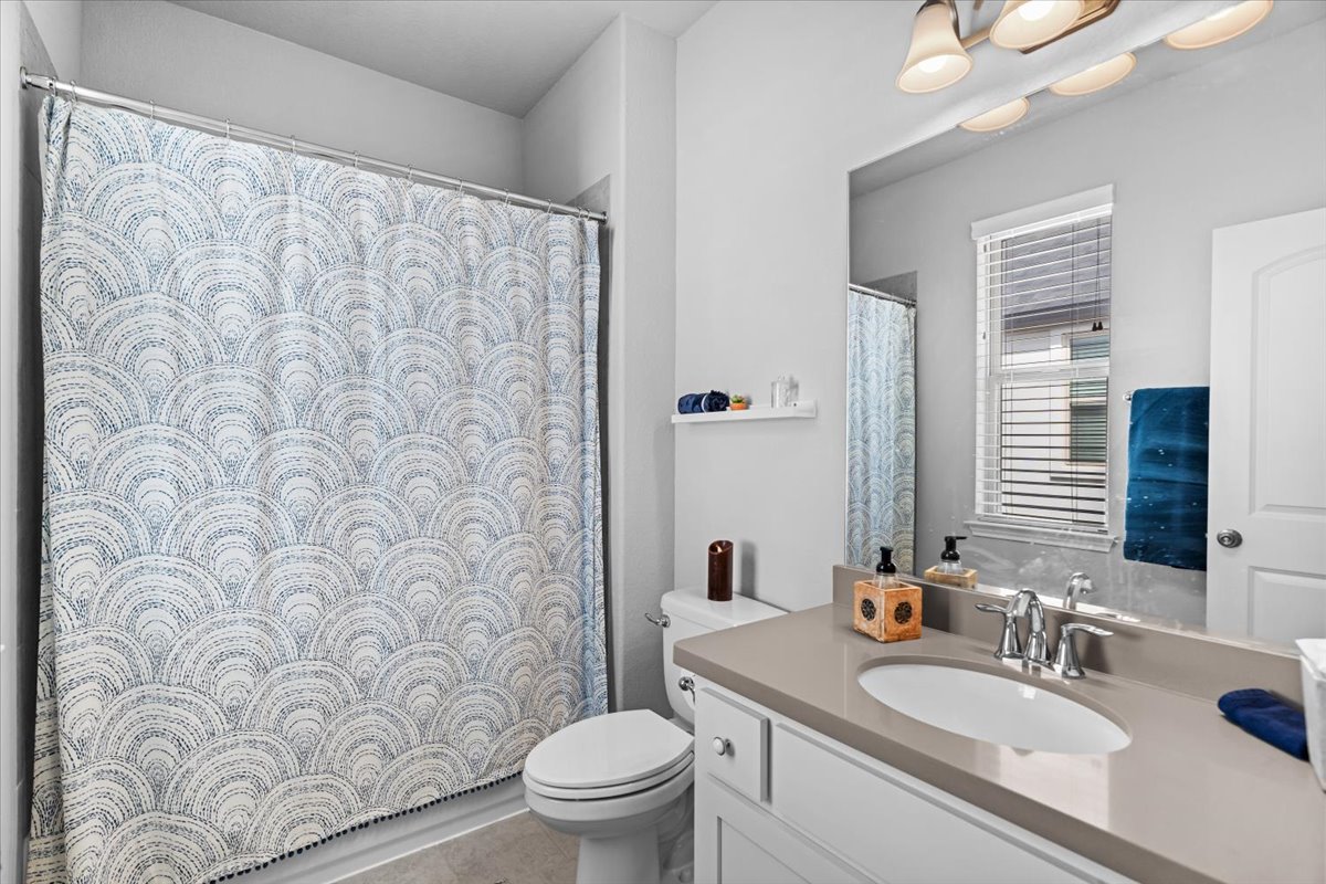 2733 Painted Sky Bend Leander, TX 78641 - Photo 27 of 35 a bathroom with a granite countertop sink a toilet and a mirror