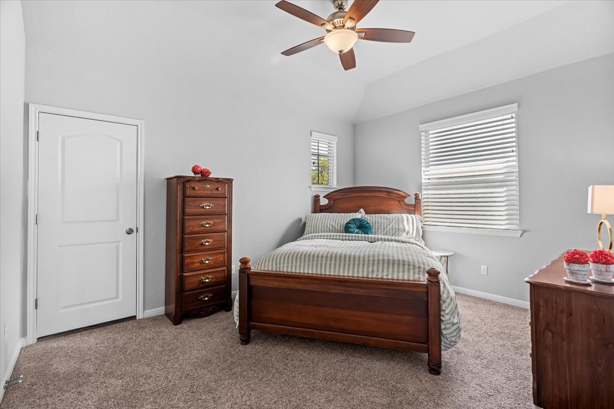 2733 Painted Sky Bend Leander, TX 78641 - Photo 30 of 35 a bedroom with a bed and a chandelier