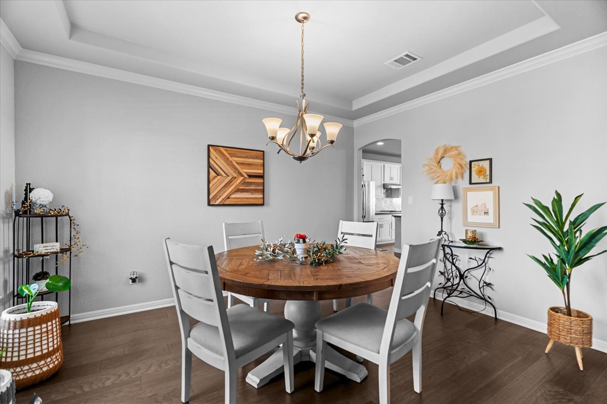 2733 Painted Sky Bend Leander, TX 78641 - Photo 7 of 35 a view of a dining room with furniture wooden floor and chandelier