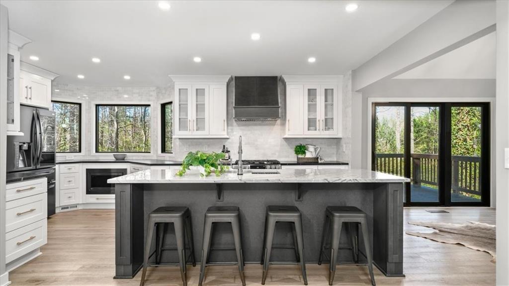 a kitchen with kitchen island granite countertop a sink and stainless steel appliances