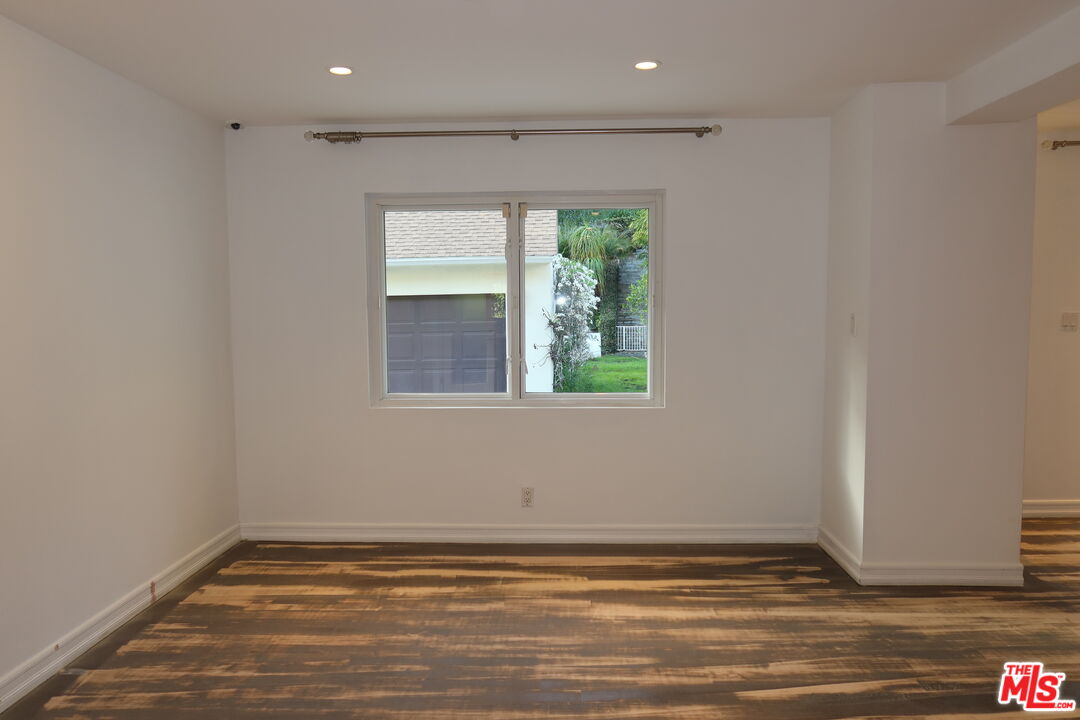 1617 Roscomare Road Los Angeles, CA 90077 - Photo 5 of 12 a view of an empty room with wooden floor and a window