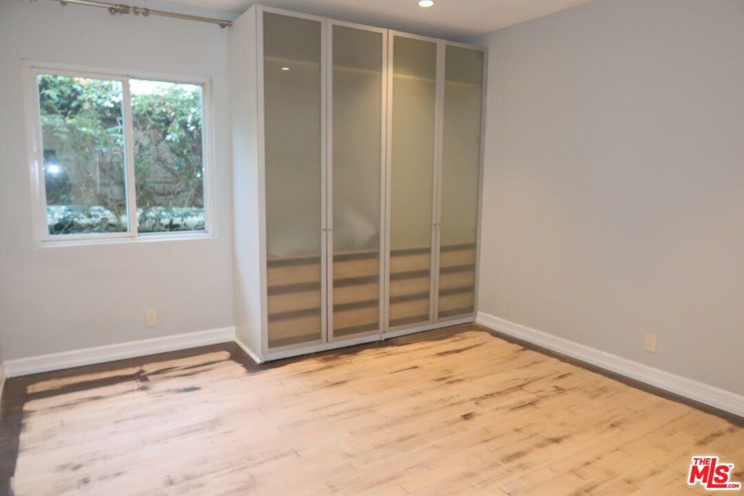 1617 Roscomare Road Los Angeles, CA 90077 - Photo 9 of 12 an empty room with a wooden floor and doors