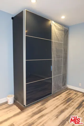 a room with walk in closet and wooden floor