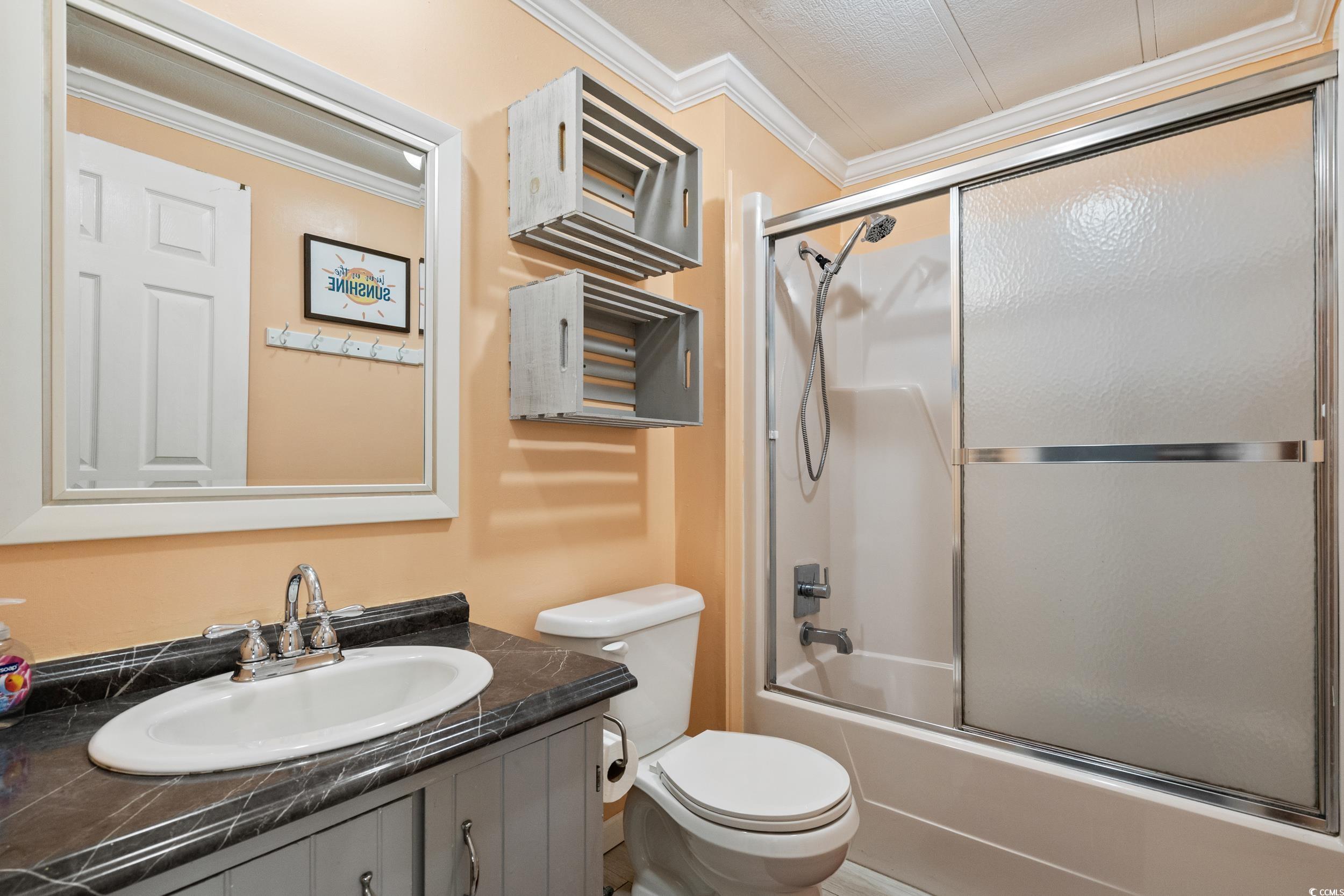 2003 Bittern Drive Myrtle Beach, SC 29575 - Photo 18 of 40 Full bathroom featuring vanity, enclosed tub / shower combo, ornamental molding, toilet, and a textured ceiling