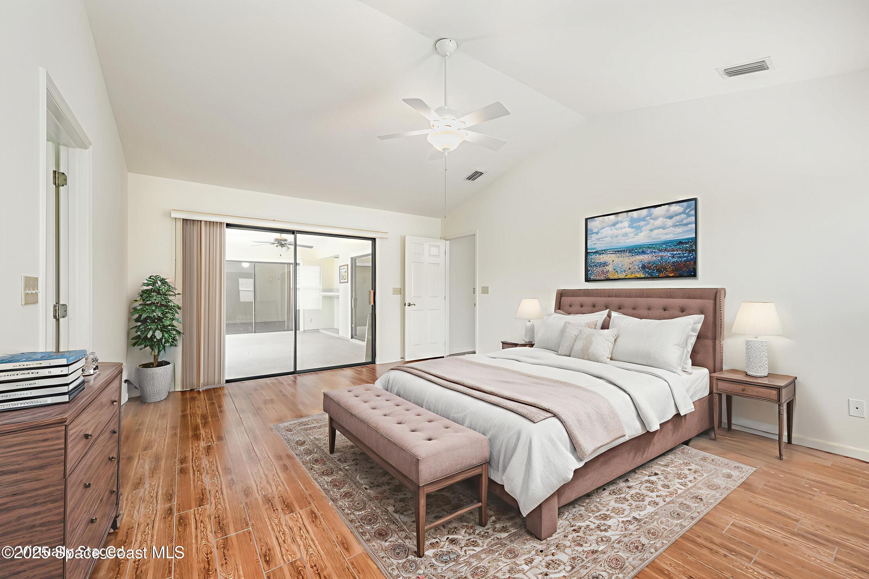 1652 Independence Avenue Melbourne, FL 32940 - Photo 14 of 38 a bedroom with a large bed and a chandelier