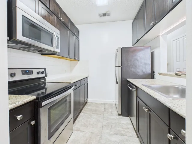 a kitchen with stainless steel appliances granite countertop a sink and a stove