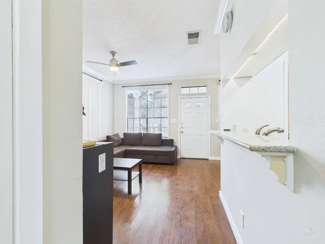 a living room with furniture and a wooden floor