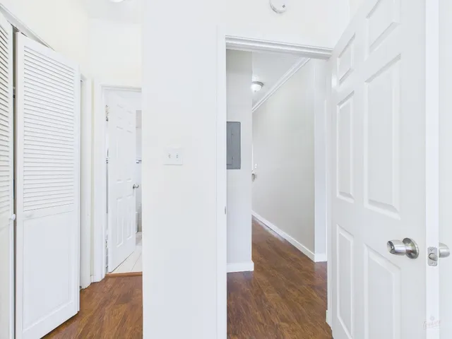a view of a hallway with wooden floor