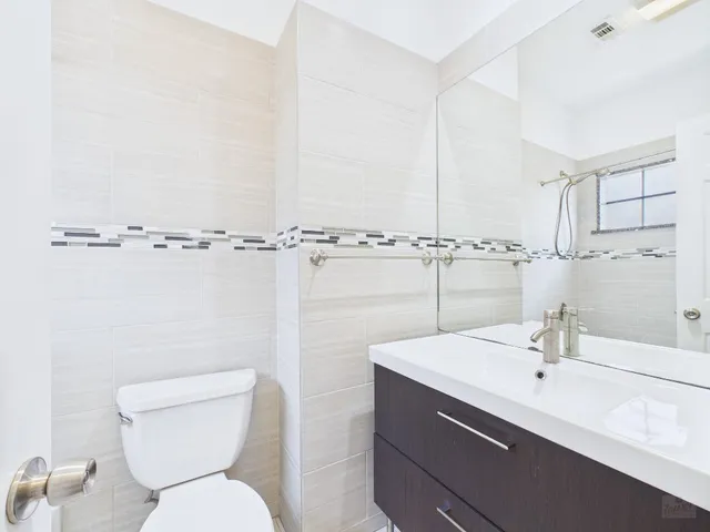 a bathroom with a sink mirror vanity and toilet