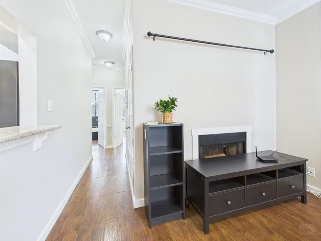 a view of a hallway with workspace and wooden floor