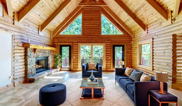 a living room with furniture a fireplace and a large window
