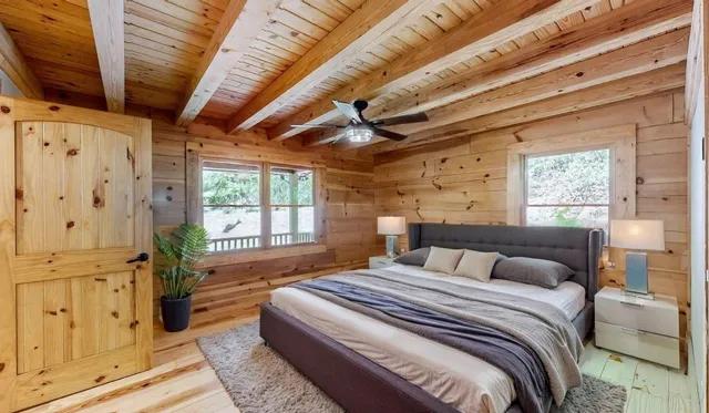 a bedroom with a bed flat screen tv and a large window