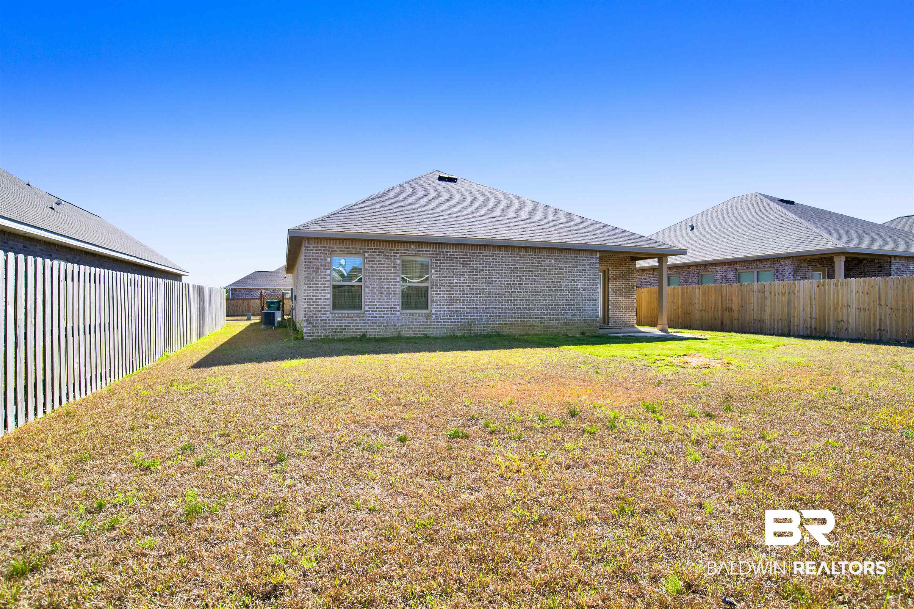 1174 Pheasant Circle Foley, AL 36535 - Photo 28 of 29 Back of house with a patio, brick siding, roof with shingles, and a fenced backyard