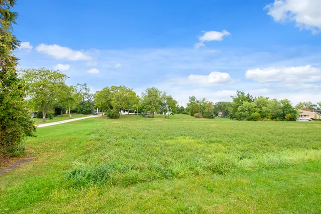 a view of a green field with wooden fence