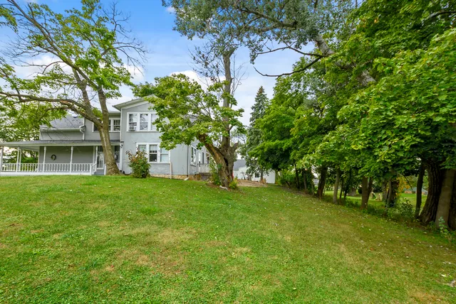 a backyard of a house with lots of green space and fountain