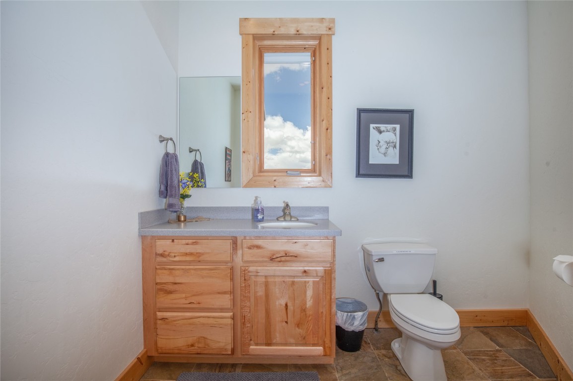 301 Polaris Road Fairplay, CO 80440 - Photo 13 of 35 a bathroom with a granite countertop toilet a mirror and a sink