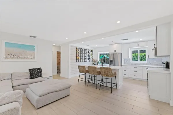 a kitchen with stainless steel appliances a refrigerator sink and white cabinets
