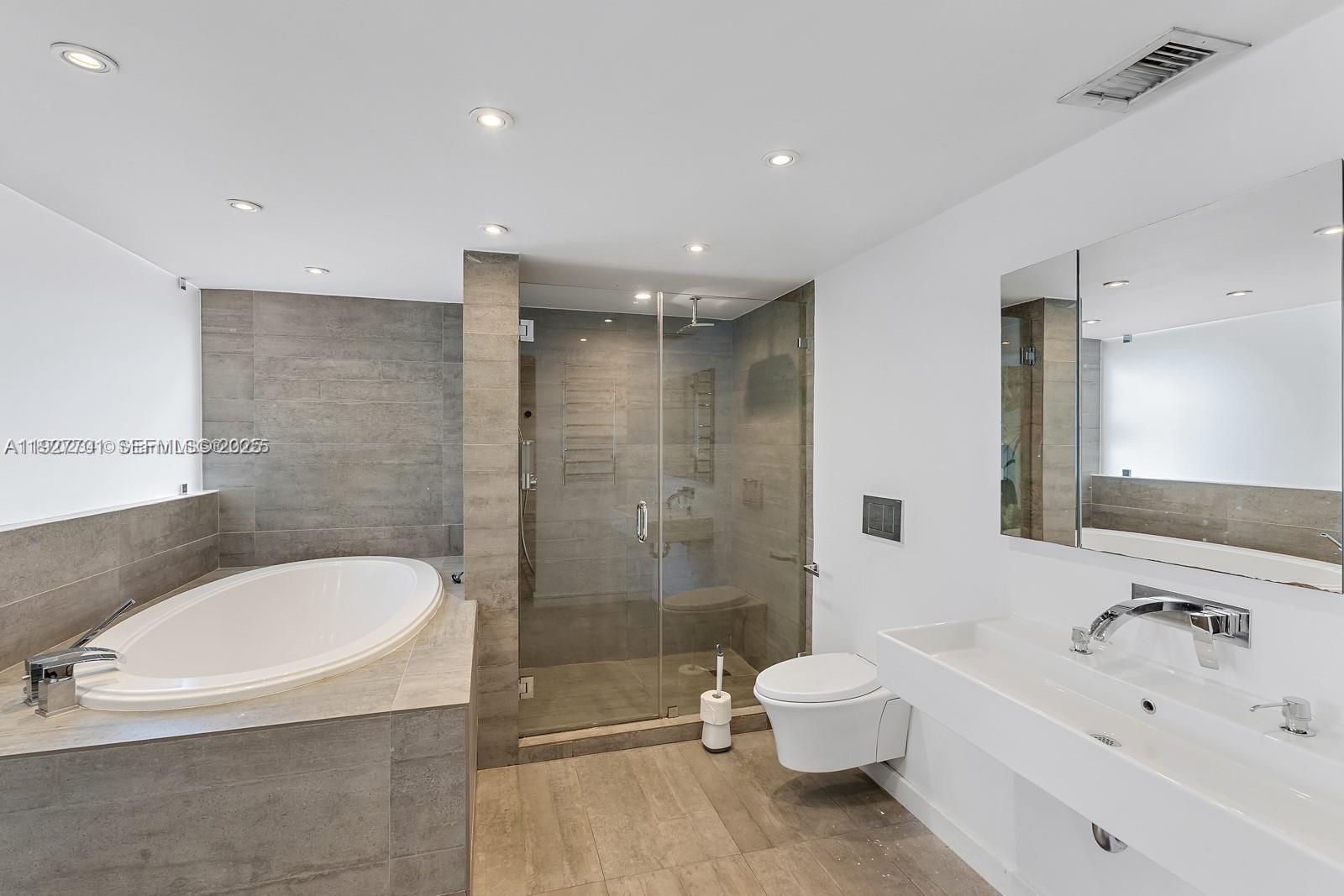 100 Ocean Ln Drive, Unit 304 Key Biscayne, FL 33149 - Photo 20 of 28 a bathroom with a bathtub shower sink mirror and toilet