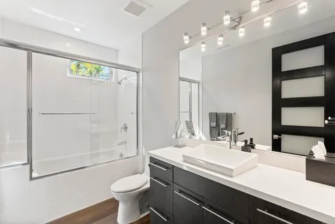 a bathroom with a sink a toilet and shower