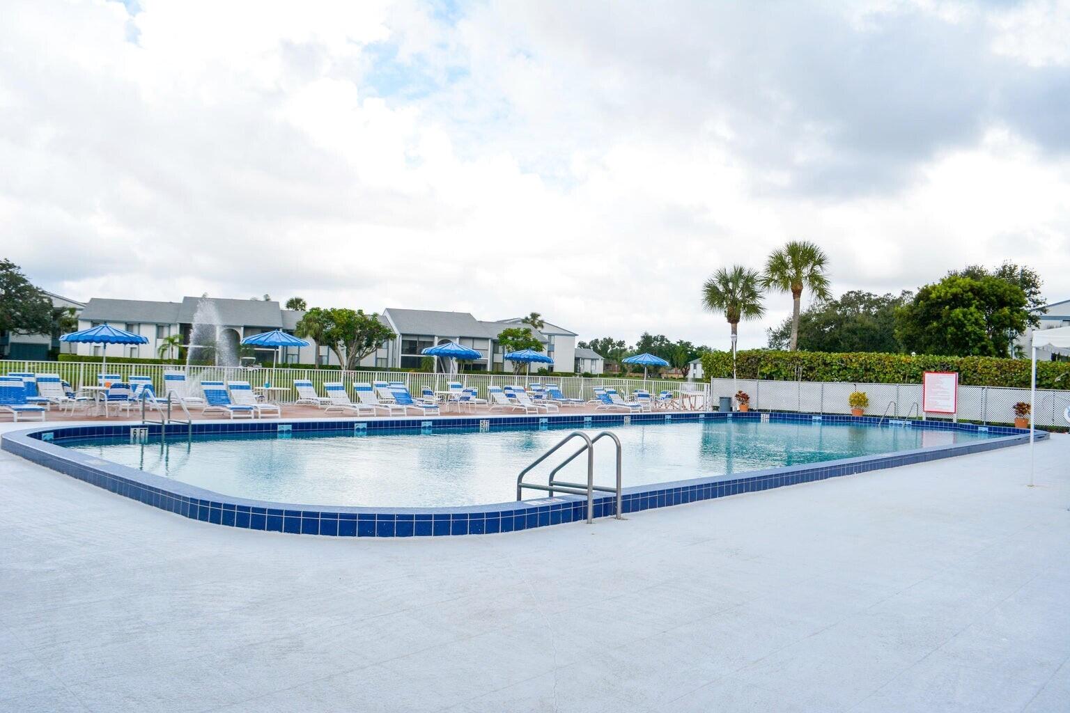 1006 Green Pine Boulevard, Unit A1 West Palm Beach, FL 33409 - Photo 23 of 25 a view of a swimming pool and a yard