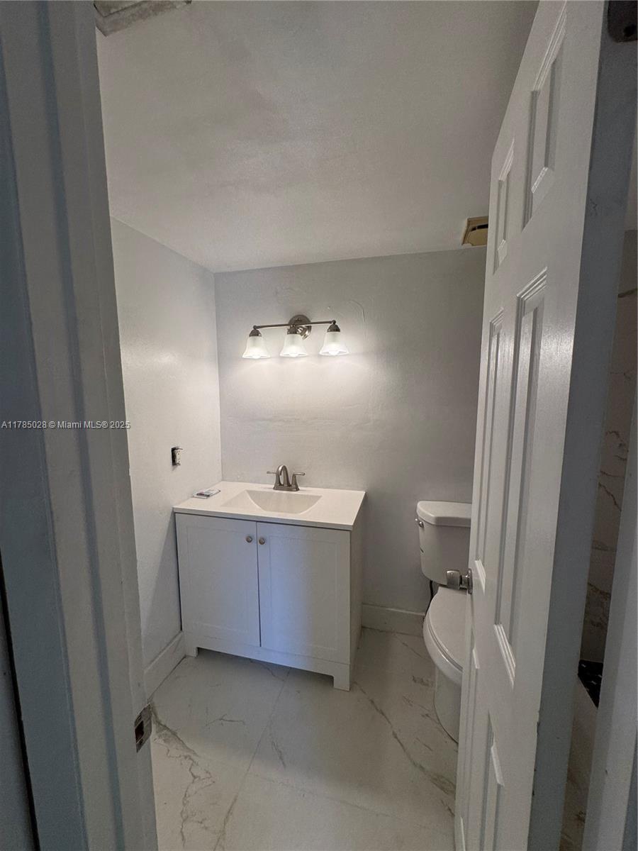 10353 North Kendall Drive, Unit BB2 Miami, FL 33176 - Photo 11 of 20 a bathroom with a sink and mirror with toilet