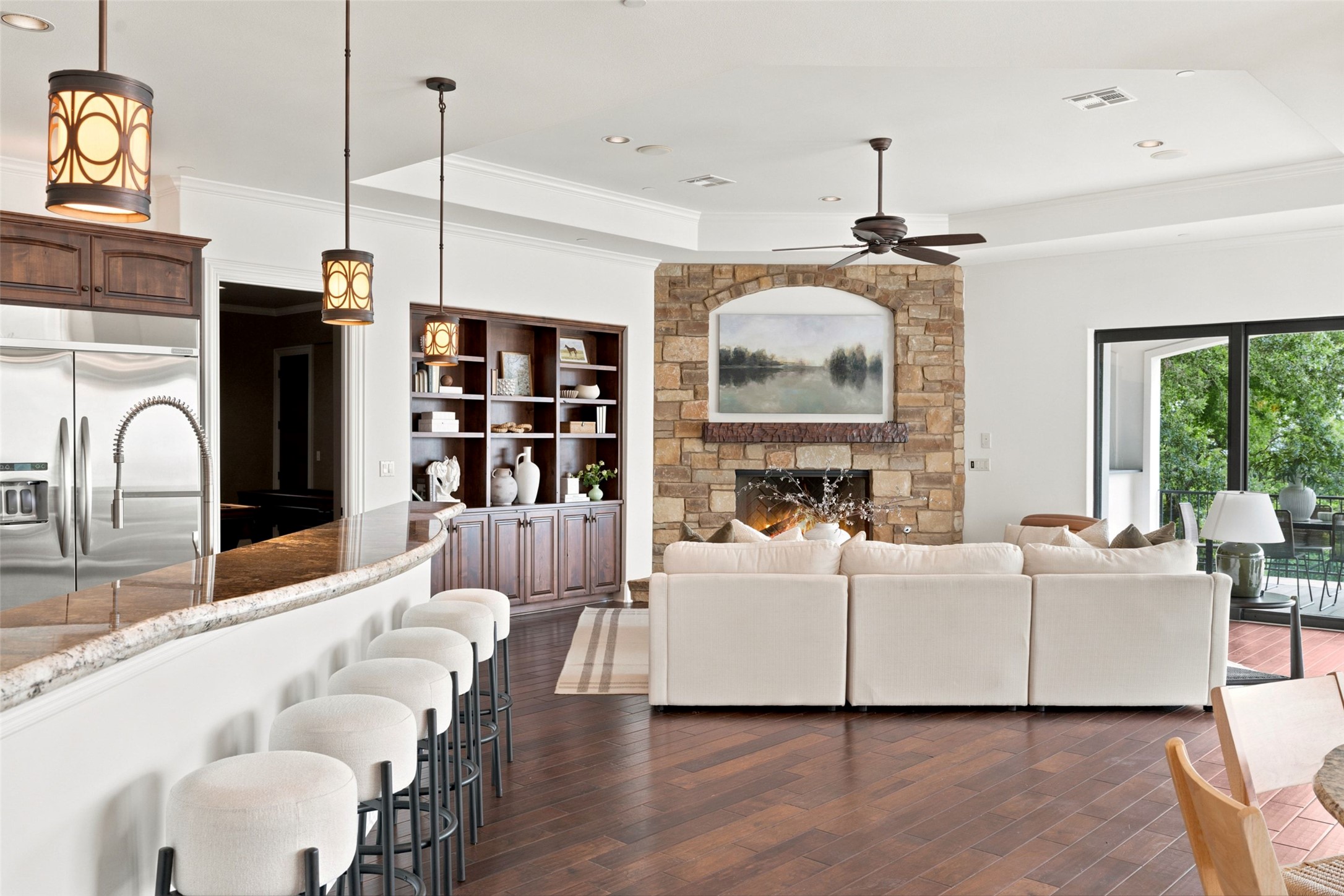 1414 The High Road Austin, TX 78746 - Photo 13 of 40 An inviting open-concept living area boasts a rustic stone fireplace and built-in shelving, perfect for entertaining.