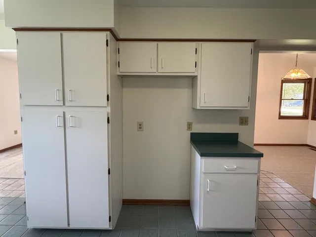 a kitchen with granite countertop white cabinets and white appliances