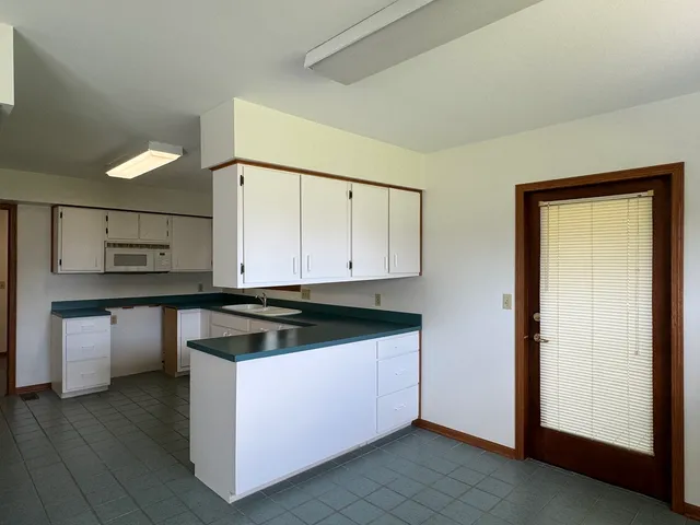 a kitchen with granite countertop a sink and a stove top oven