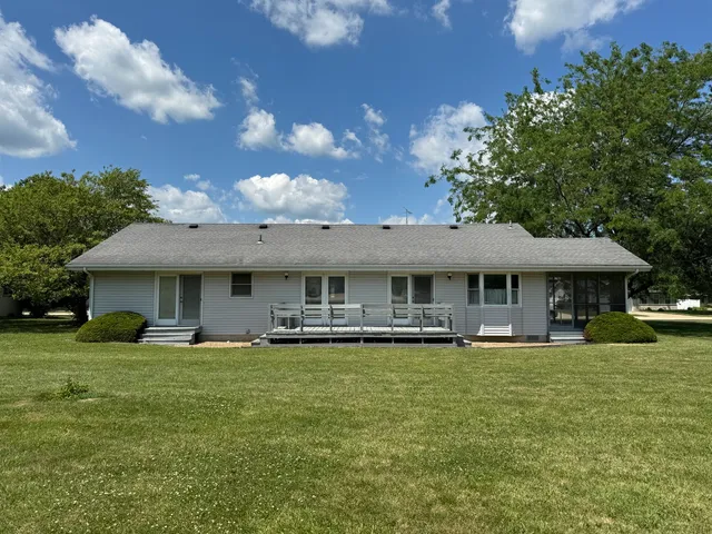a view of a house with a yard and sitting area