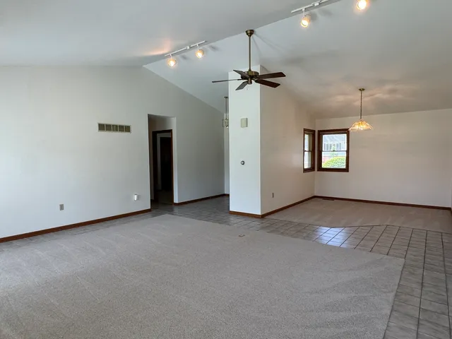 a view of a big room with windows and chandelier fan