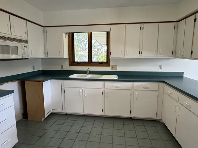 a kitchen with white cabinets a sink and a stove