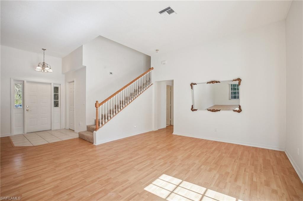 5348 Cypress Lane Naples, FL 34113 - Photo 10 of 28 a view of a hallway with wooden floor and staircase