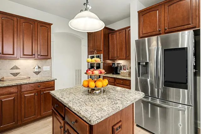 a kitchen with stainless steel appliances granite countertop a refrigerator and a sink