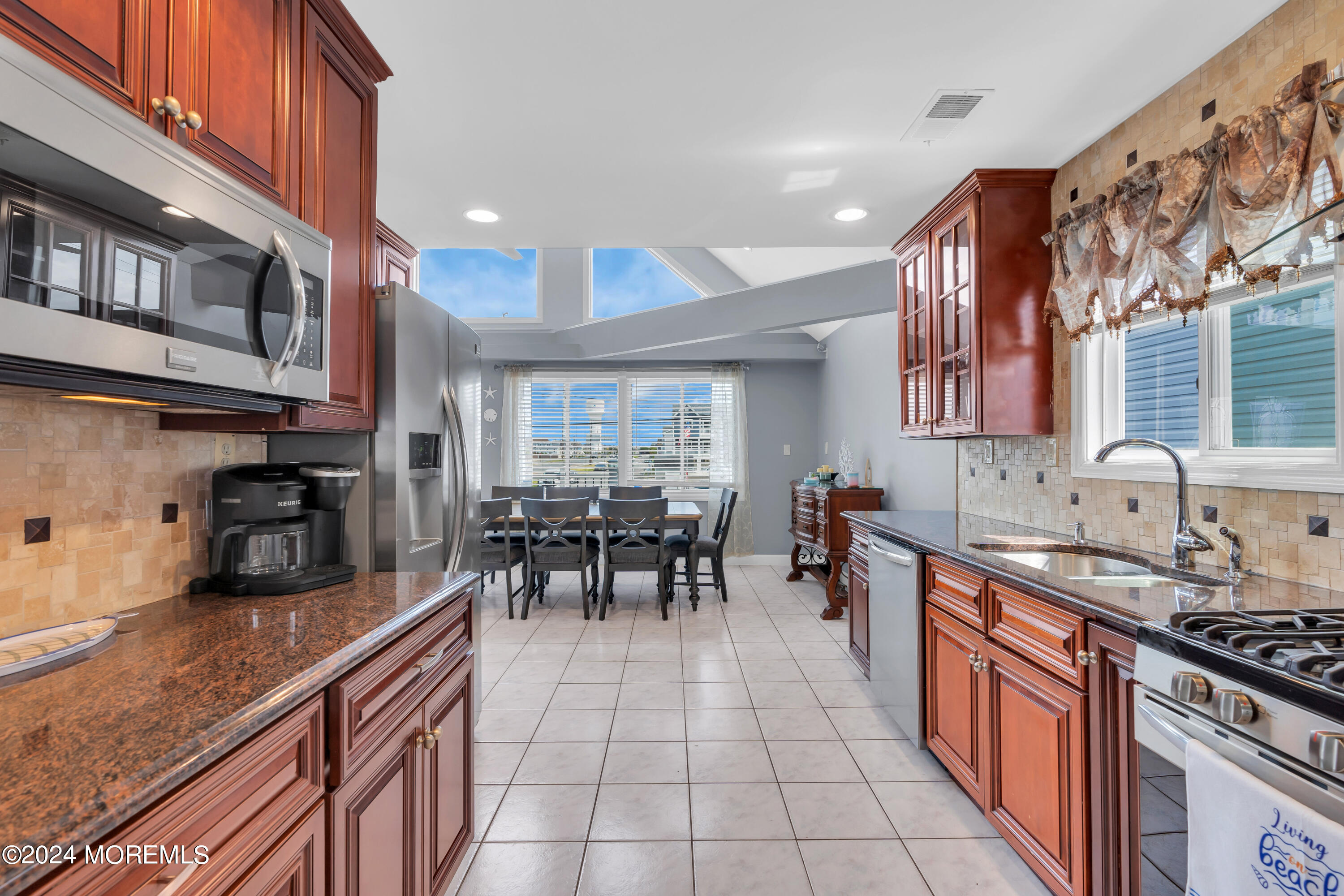117 Harding Avenue Seaside Heights, NJ 08751 - Photo 12 of 28 a kitchen with stainless steel appliances granite countertop a stove a sink a oven a dining table and chairs with wooden floor